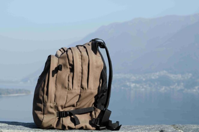 
					A closeup shot of a big hiking backpack with the blurry mountains in the background